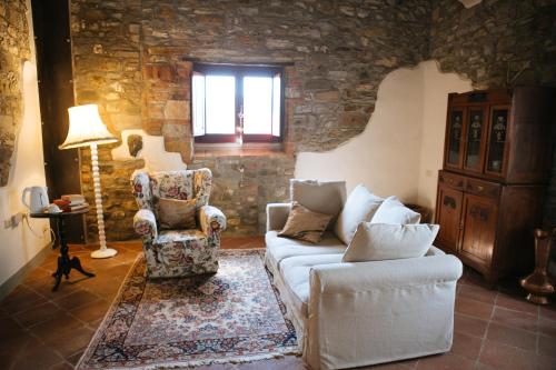 a living room with a couch and a chair at Podere Terreno alla via della volpaia in Radda in Chianti