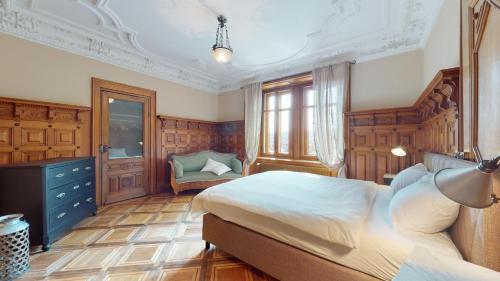 - une chambre avec un grand lit et une chaise dans l'établissement Architectural gem with vintage charm, à La Chaux-de-Fonds