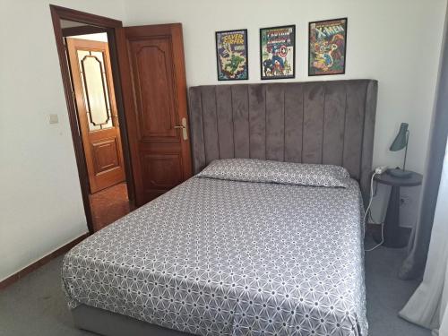 1 dormitorio con 1 cama y puerta de madera en Genial casa en centro, en Ceuta
