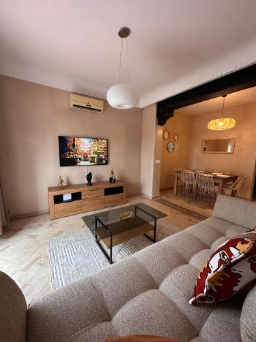 a living room with a couch and a tv at Palm View in Marrakesh