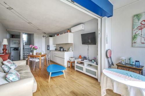 un petit salon avec un canapé et une cuisine dans l'établissement Appartement Fages climatisé - Welkeys, à La Grande Motte