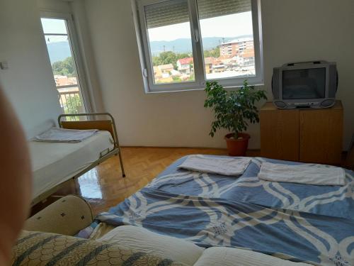 Zimmer mit 2 Betten, einem TV und Fenstern in der Unterkunft MM Apartment in a great location in Strumica, MK 6th floor in Strumica