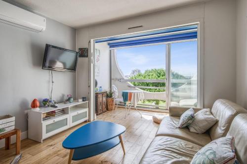 un salon avec un canapé et une grande fenêtre dans l'établissement Appartement Fages climatisé - Welkeys, à La Grande Motte