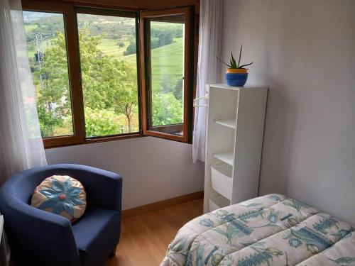MerodioにあるVilla Vacacional Casa Merodioのベッドルーム(青い椅子、窓付)