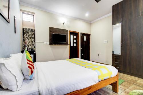a bedroom with a bed and a tv on the wall at Home Vp Inn in Vānivilāsa Puram