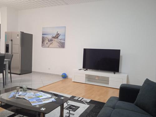 sala de estar con TV, sofá y mesa en D&D Lausic Apartment, en Dugi Rat