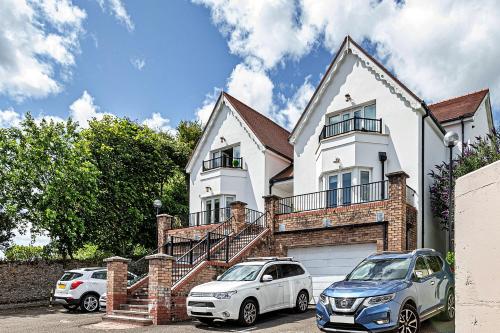 a white house with two cars parked in front of it at Finest Retreats - Y Lle Hapus in Tenby
