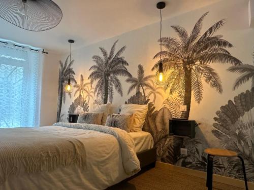 a bedroom with a bed with palm trees on the wall at Bulles de Nature 