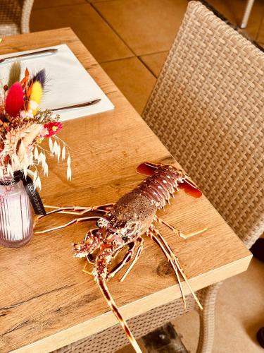 a lobster sitting on top of a wooden table at Hotel Restaurant L'Europe in Saint-Florent