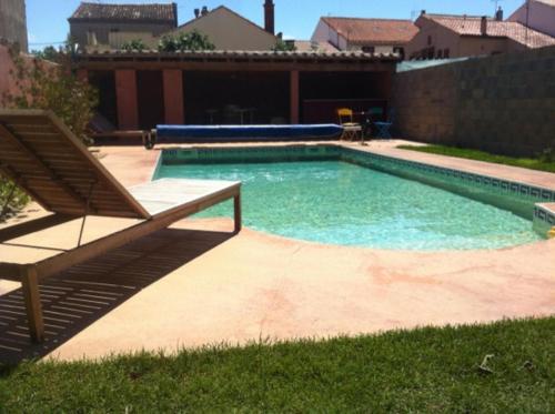 una piscina con una silla y un banco en La Cathare, en Lézignan-Corbières