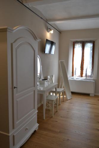 um quarto com uma porta branca e uma mesa e cadeiras em La Locanda nel Frutteto em Rovereto