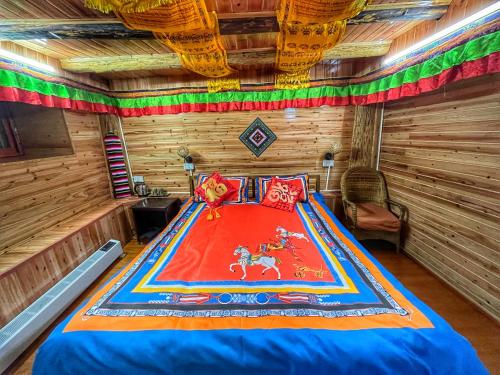 1 dormitorio con 1 cama en una cabaña de madera en Tavern Hostel仁和客栈 en Shangri-La