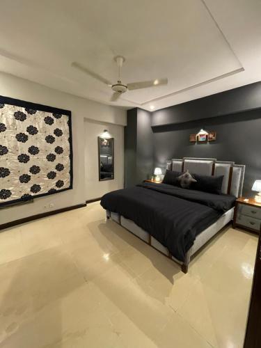 a bedroom with a bed and a painting on the wall at Freddy's Family Apartments in Islamabad