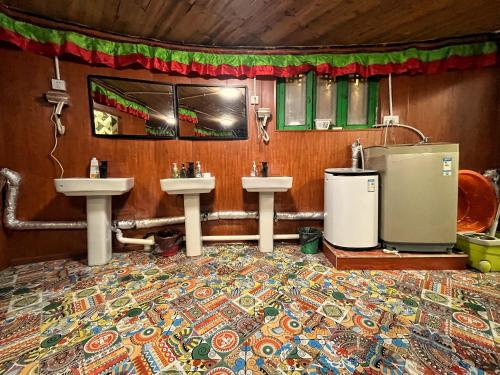 a bathroom with two sinks and a rug at Tavern Hostel仁和客栈 in Shangri-La