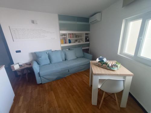 un soggiorno con divano blu e tavolo di Celeste - affitti brevi a Polignano a Mare