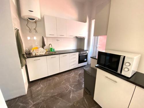 波尔图BREINER 54的配有白色橱柜和微波炉的厨房