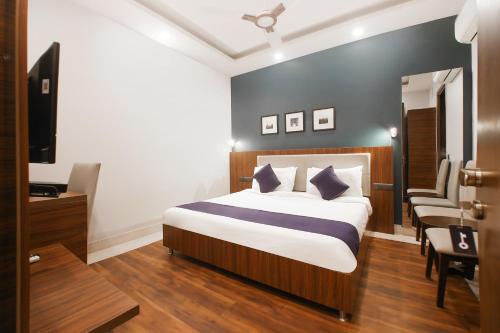 una camera con letto, scrivania e TV di SilverKey M&m Residency a Nuova Delhi