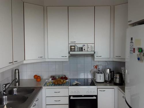 a kitchen with white cabinets and a sink at 60 neliön kaksio 300 m keskustaan in Seinäjoki