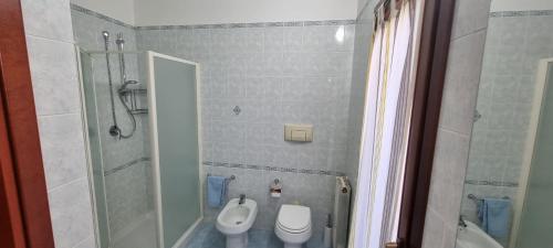 uma casa de banho com um chuveiro, um WC e um lavatório. em Le case del sole em Capoterra