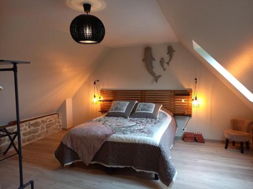 a bedroom with a large bed in a attic at Le Domaine de la petite chèvre in Ploumagoar