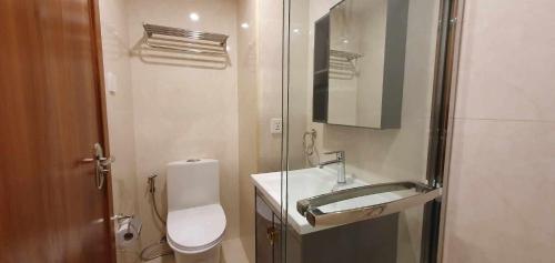 a bathroom with a toilet and a sink and a mirror at JCGA Apartments at Megatower Residences IV - Near SM & Session Rd in Baguio