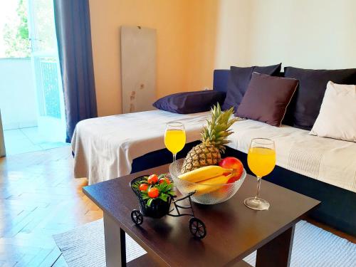 een woonkamer met een tafel met fruit en wijnglazen bij Amarena Apartment in Rijeka