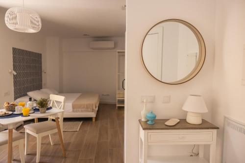 - un salon et une chambre avec une table et un miroir dans l'établissement Apartamento Especería Blue by #CuatroCallesFlats, à Malaga