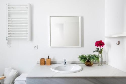 Baño blanco con lavabo y espejo en Lepanto Premium Apartments, en Sevilla