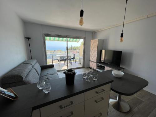 - un salon avec un canapé et une table avec des verres à vin dans l'établissement Baie des Anges, à La Ciotat