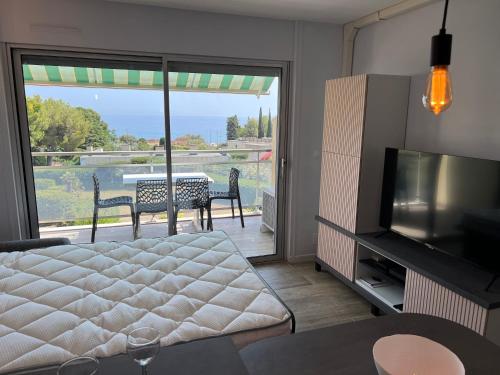 salon z łóżkiem i przesuwnymi szklanymi drzwiami w obiekcie Baie des Anges w mieście La Ciotat