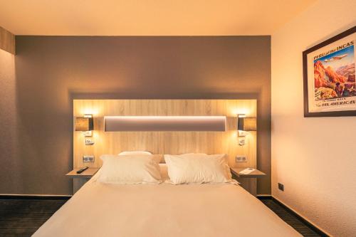 a bedroom with a large bed with white pillows at Best Western Marseille Aeroport in Vitrolles