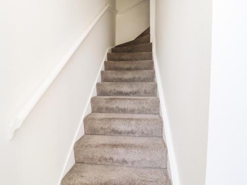 a flight of stairs in a white house at 8 Pottergate Mews in Helmsley