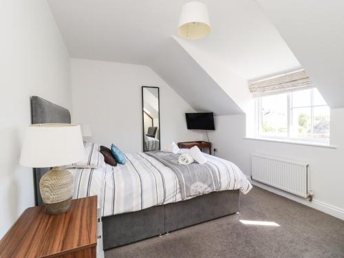a bedroom with a bed and a mirror at 8 Pottergate Mews in Helmsley