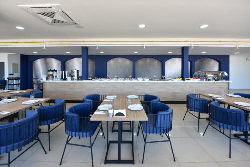 un comedor con mesas de madera y sillas azules en Sunflower Otel en Trabzon