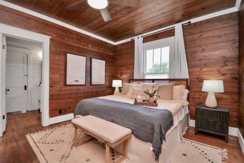 a bedroom with wooden walls and a bed and a window at Coastal Craftsman- Walk to Beach & Pleasure Pier- As seen on 'Restoring Galveston' in Galveston