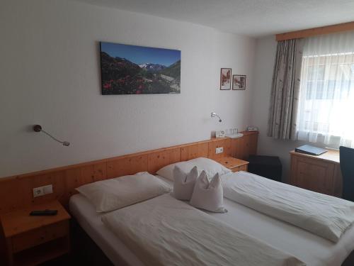 a bedroom with a bed with two pillows on it at Grünwaldhof in Tux