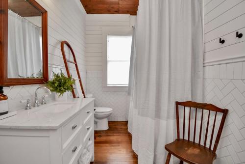 a white bathroom with a sink and a toilet at Coastal Craftsman- Walk to Beach & Pleasure Pier- As seen on 'Restoring Galveston' in Galveston