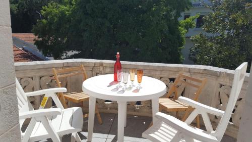 - une table blanche avec des chaises et une bouteille dans l'établissement BIARRITZ CENTRE tout à pied parking Wifi, à Biarritz