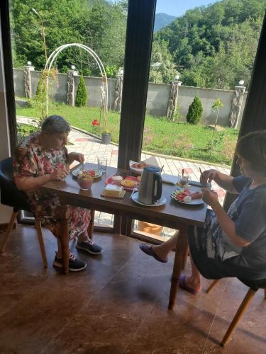 two women sitting at a table eating food at DIOSKURIA BORJOMi in Borjomi