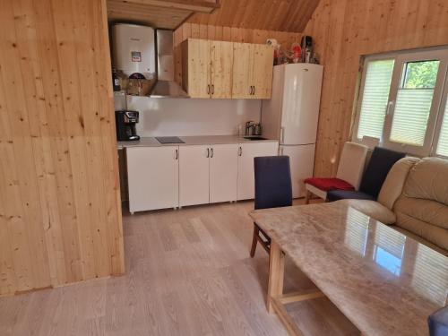 a kitchen and living room with a table and a couch at Hubane saunamaja sisehoovis in Tartu