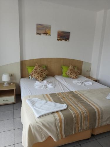 een slaapkamer met 2 bedden en handdoeken bij Alba Family Club Hotel in Primorsko