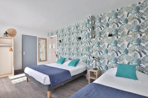 Habitación de hotel con 2 camas y papel pintado azul y blanco en Hotel du Cap en Capbreton