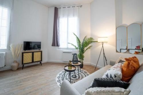 ein Wohnzimmer mit einem Sofa und einem TV in der Unterkunft Bright 30 m near the Place de la Comédie in Montpellier