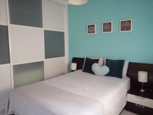 a bedroom with a white bed with a heart pillow at Piso en San Fernando (Cádiz) in San Fernando