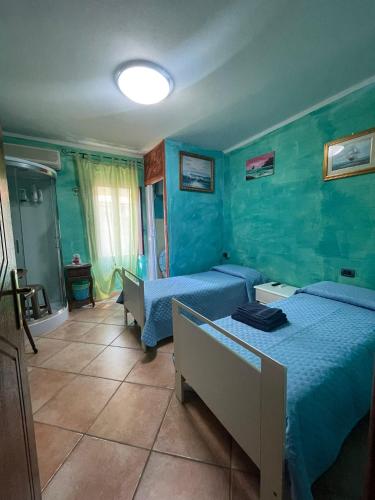 2 letti in una camera con pareti blu di Casa Ortu a Milis