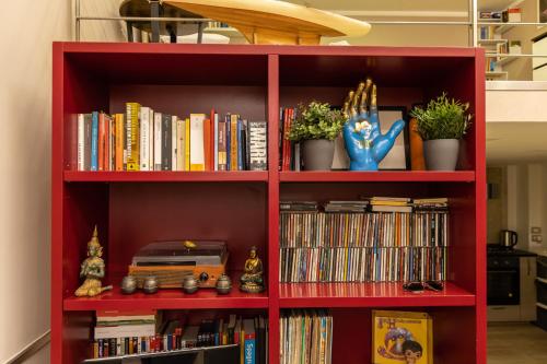 a red book shelf filled with books and dvds at Poseidon's Creek - Luxury Apartment in Naples