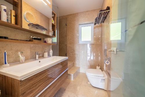 ein Badezimmer mit einer Badewanne, einem WC und einem Waschbecken in der Unterkunft Villa Sabine Apartment Cres in Medveja