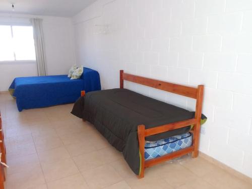 1 dormitorio con 2 camas en una habitación con ventana en Departamentos el Peregrino en San Luis
