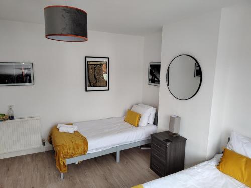um quarto com 2 camas e um espelho em Wavertree Drive 3 bed contractor home in Leicester em Leicester