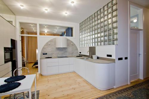 een keuken met witte kasten en een aanrecht bij New Port Apartment Gdańsk in Gdańsk